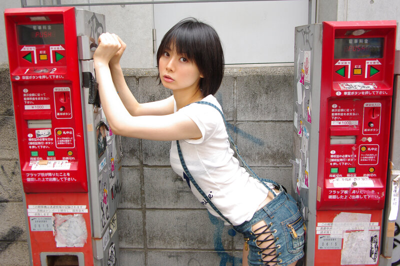 woman leaning between parking meters