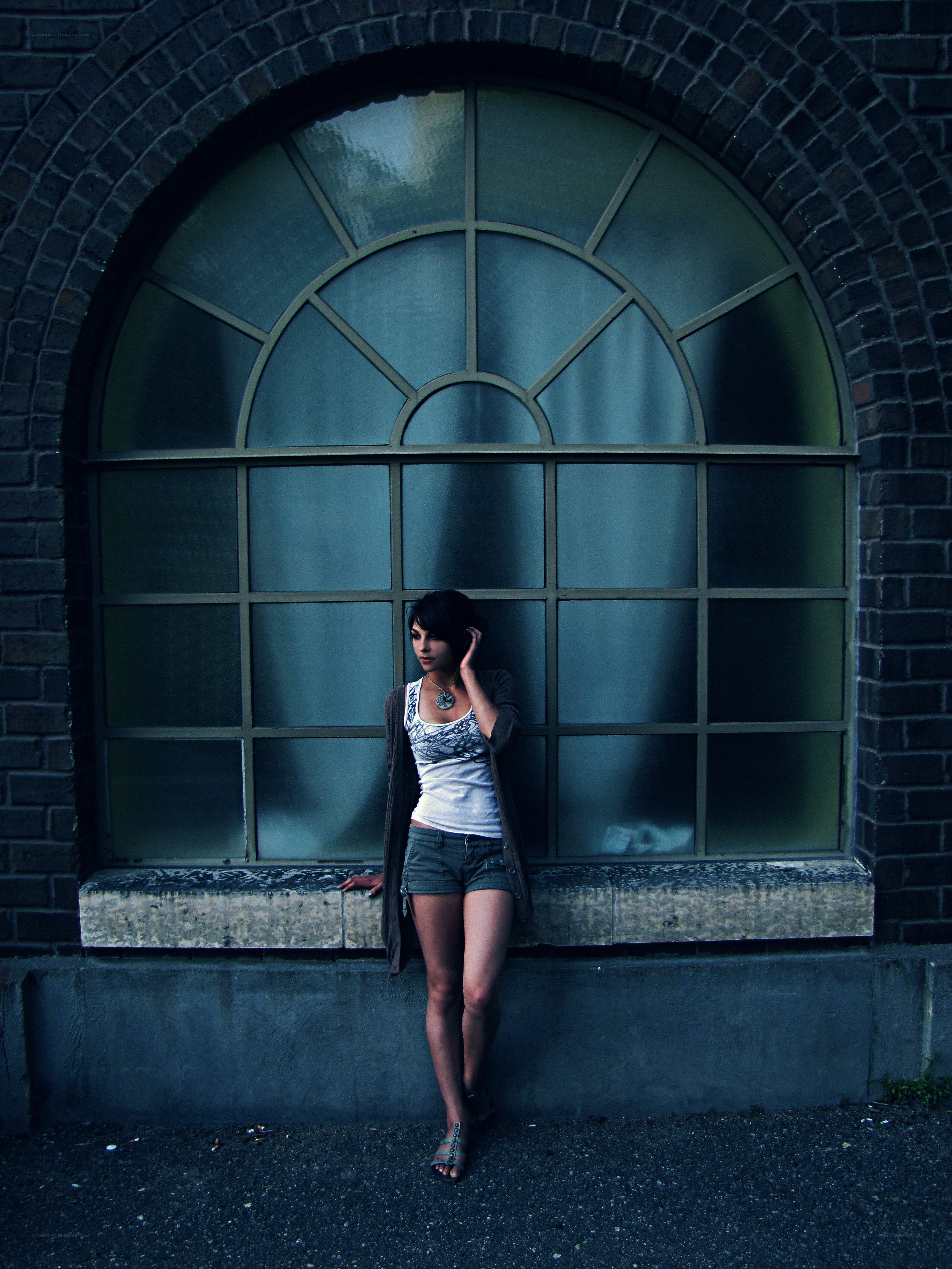 woman leaning by arched window
