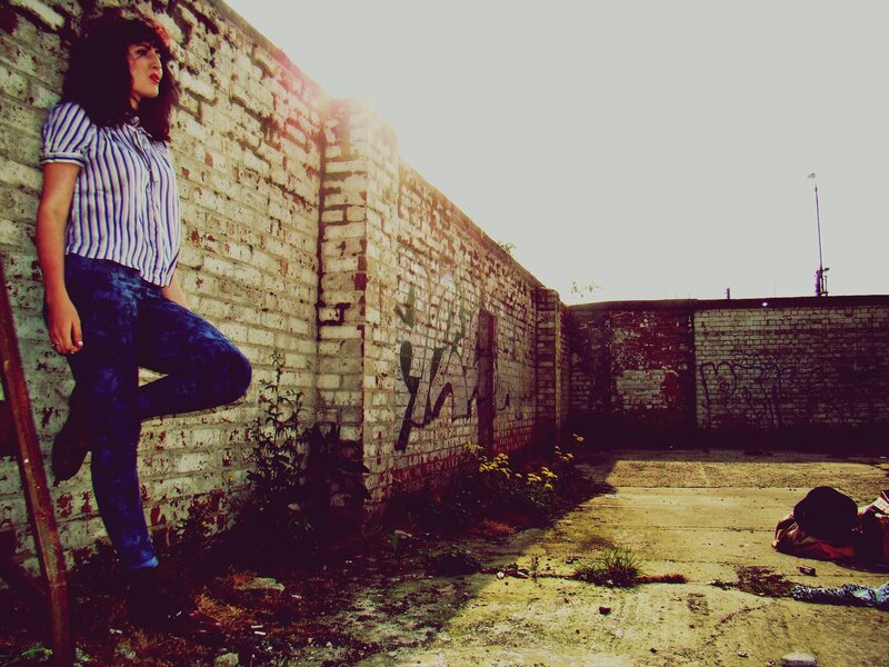 Woman leaning on a brick wall