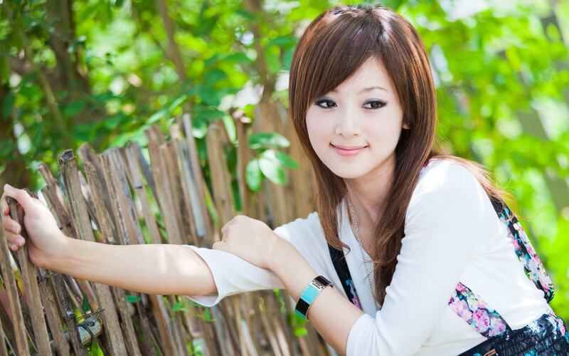woman leaning on bamboo fence