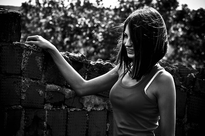woman leaning on brick wall