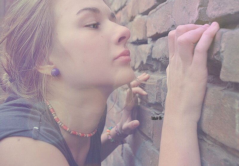 woman leaning on brick wall