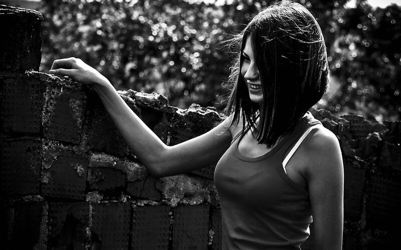 woman leaning on brick wall