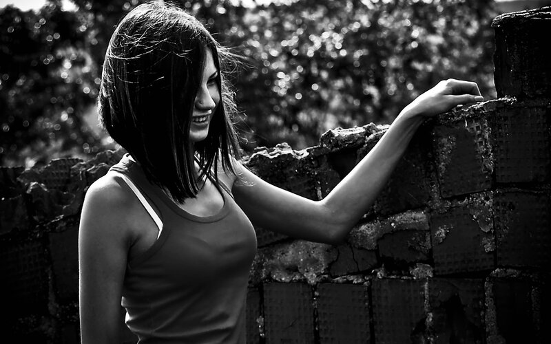 woman leaning on brick wall