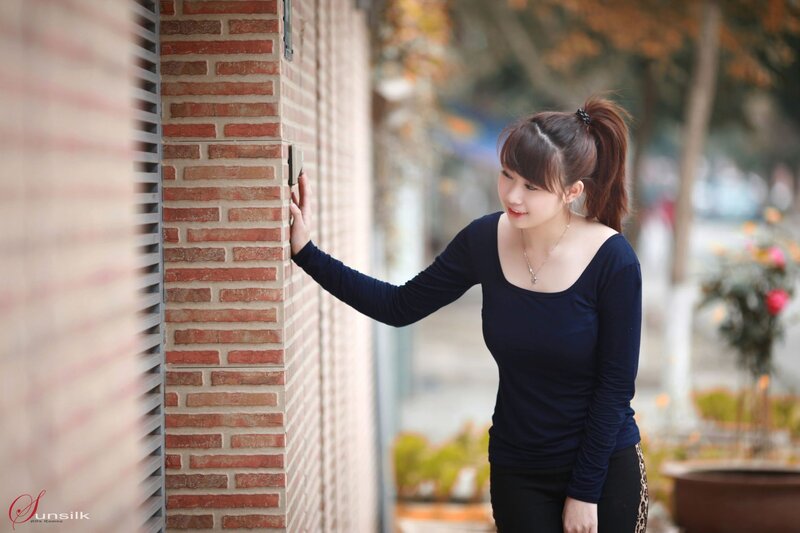 Woman Leaning on Brick Wall — Blue