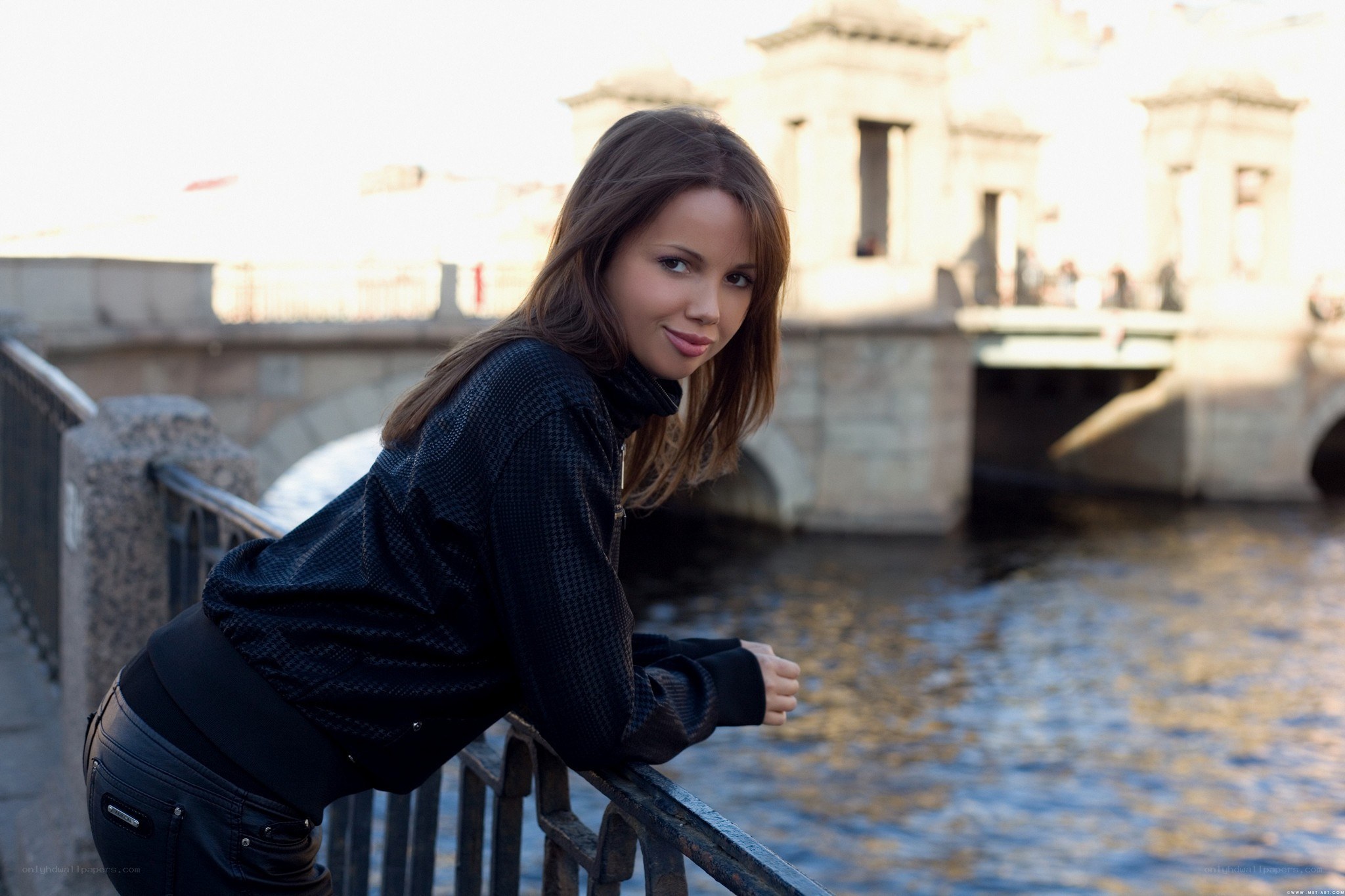 woman leaning on bridge railing