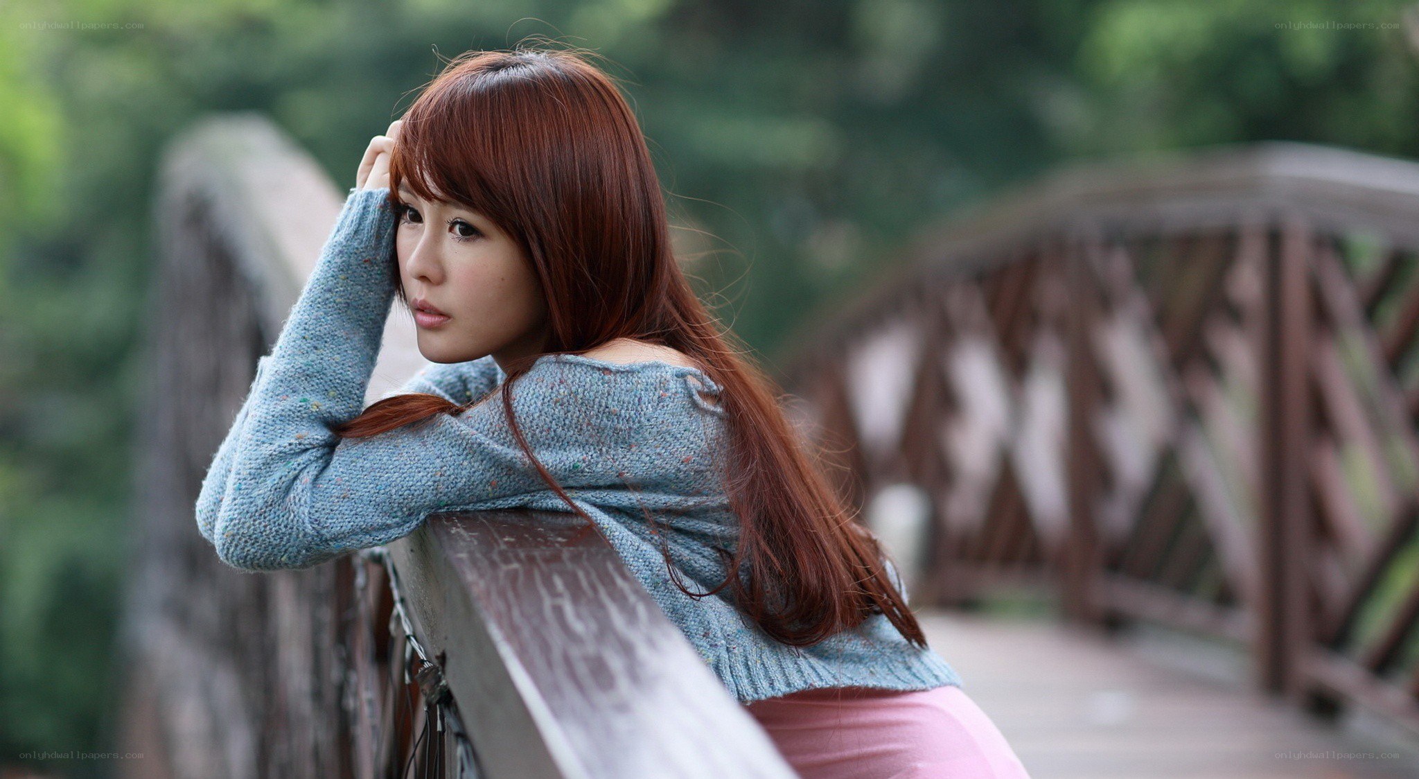 woman leaning on bridge railing