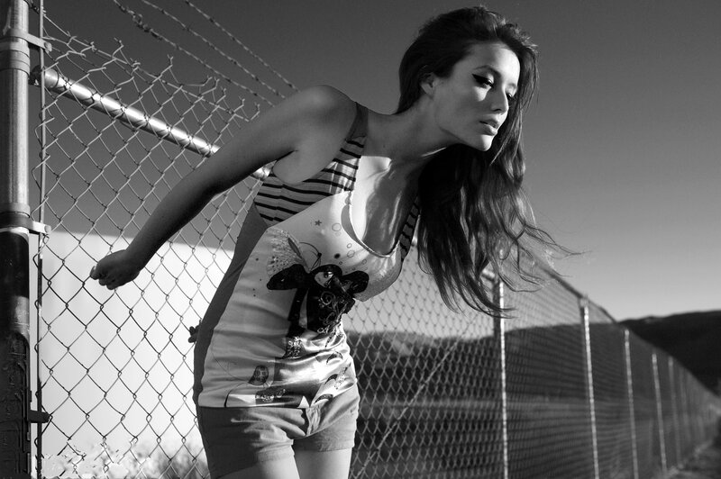 woman leaning on chain-link fence