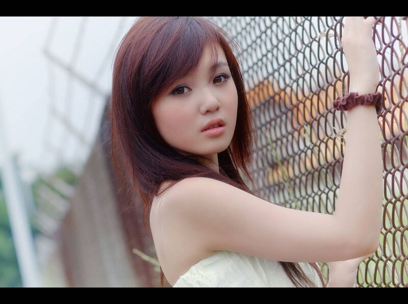 woman leaning on chain-link fence