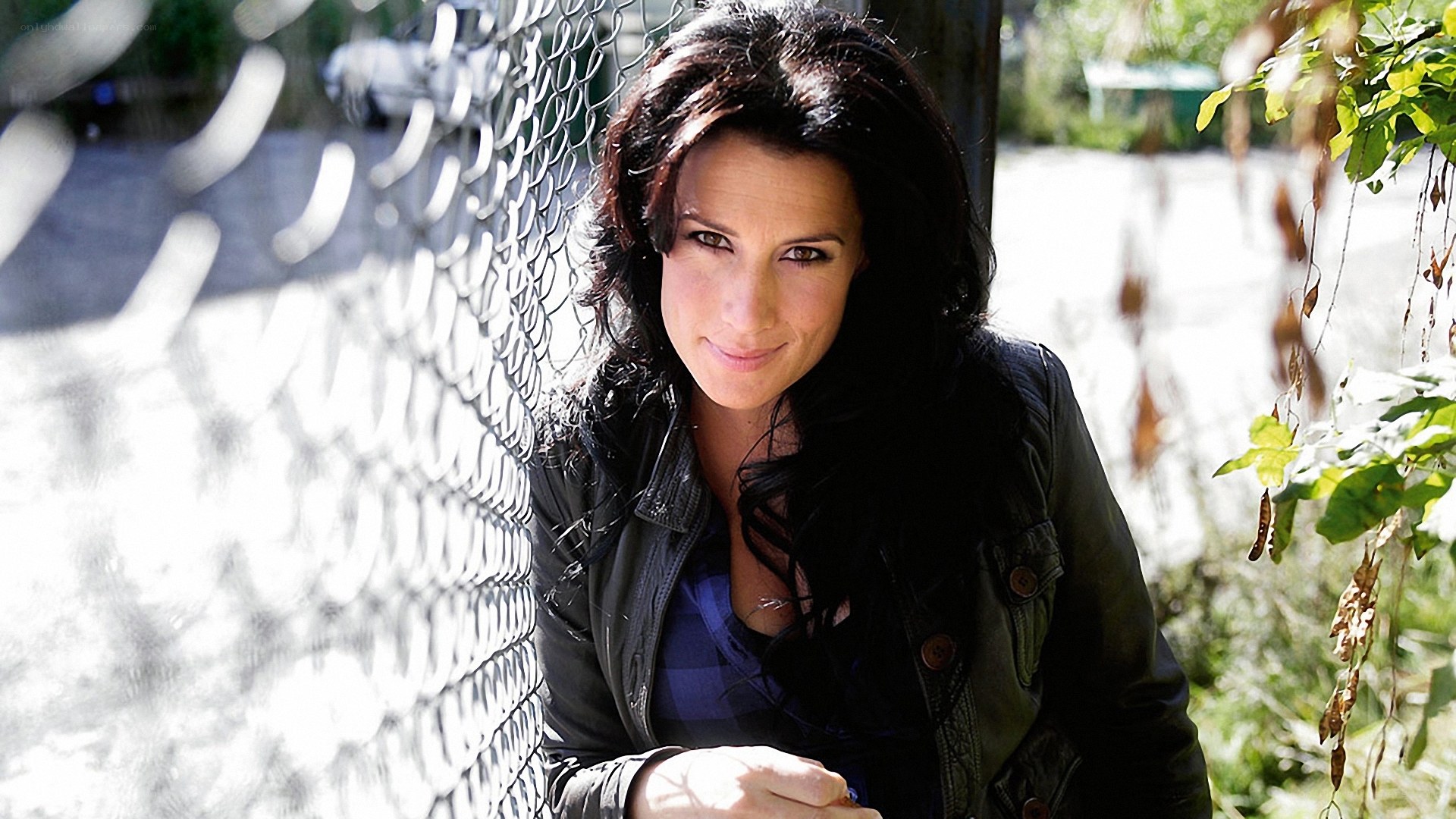woman leaning on chain-link fence