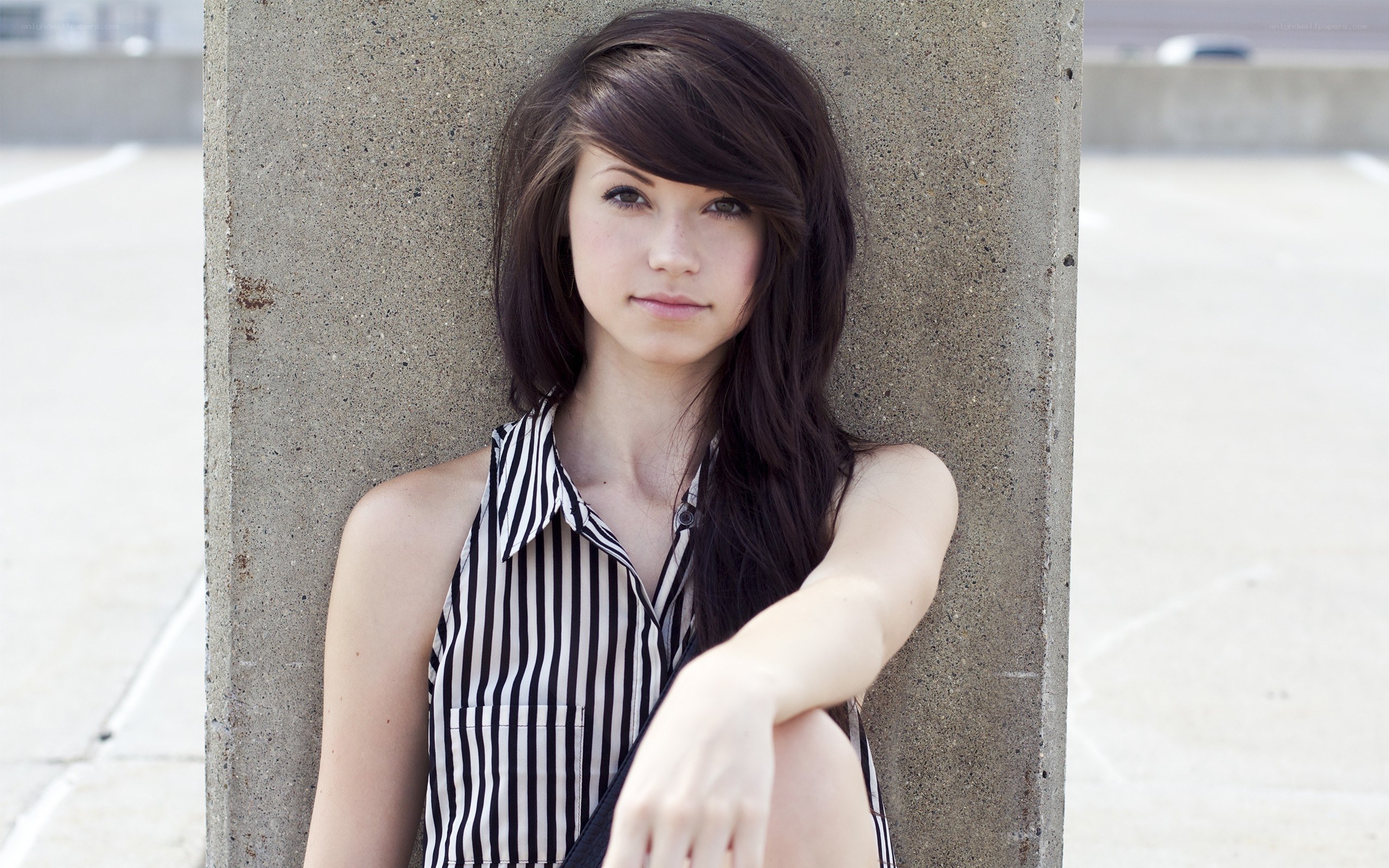 woman leaning on concrete pillar