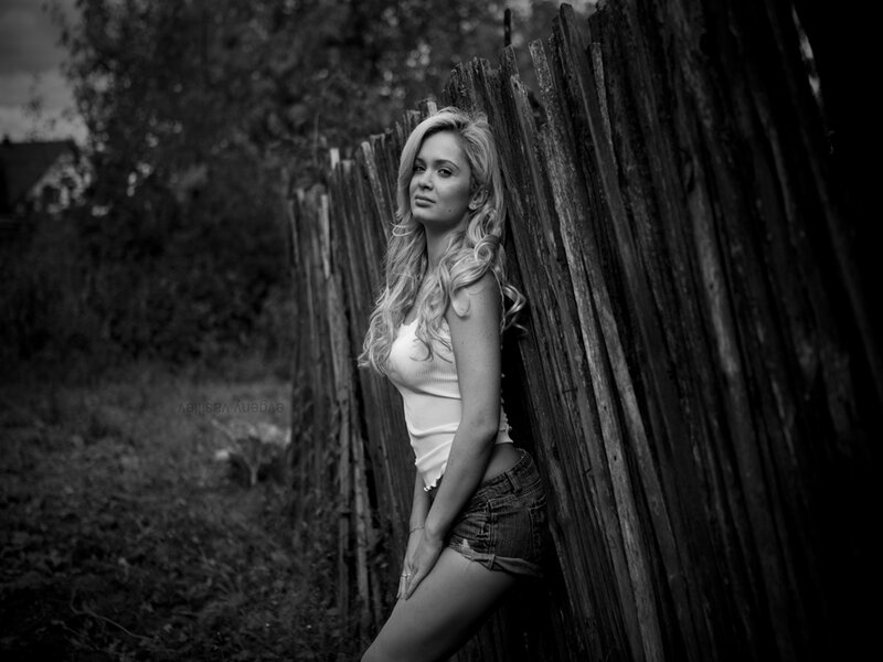 Woman Leaning on Fence — Black, Dramatic