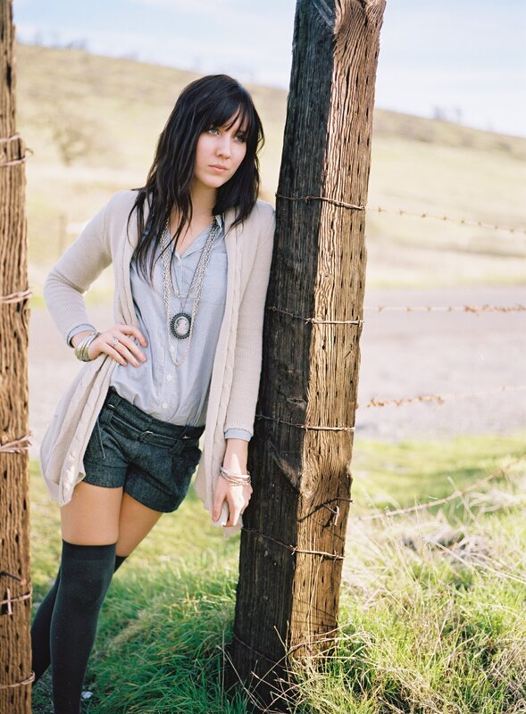 woman leaning on fence post
