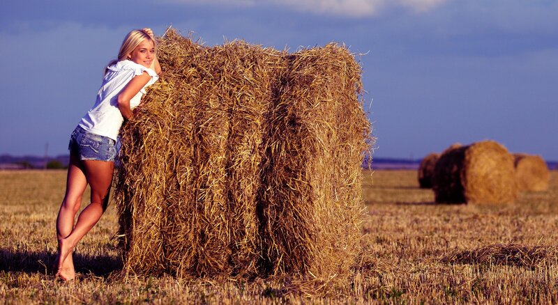 Woman leaning on hay bale