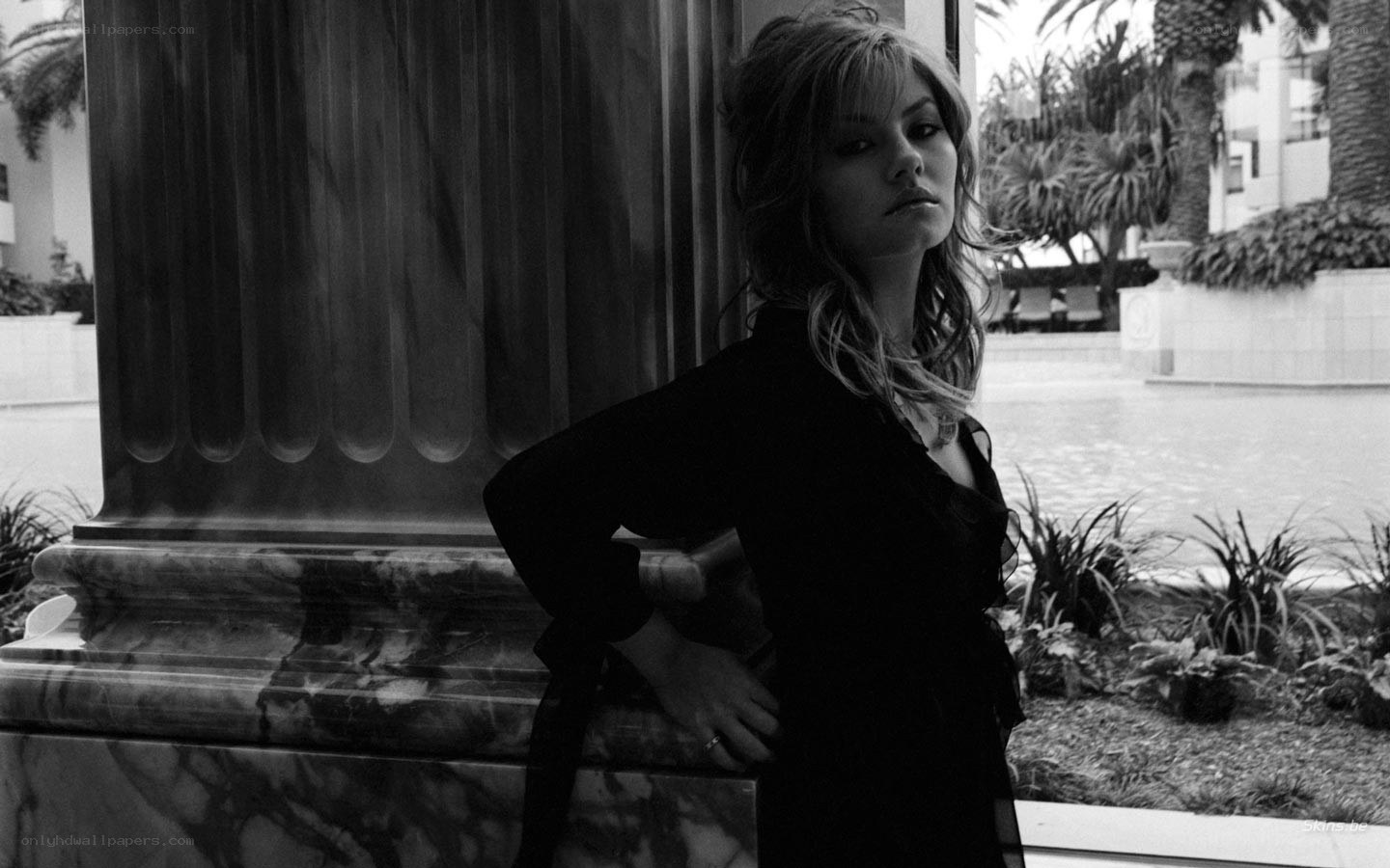 woman leaning on marble column