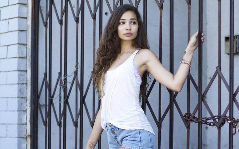woman leaning on metal gate