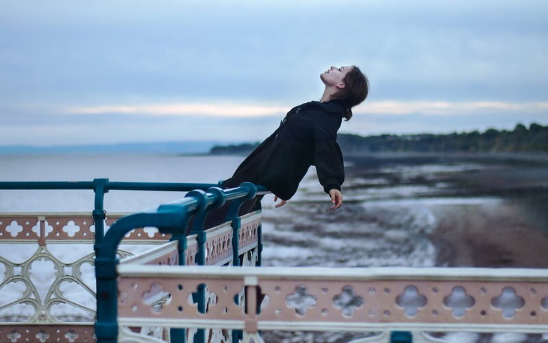 Woman leaning on pier railing