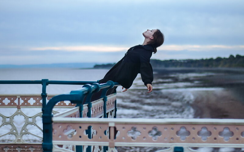 Woman leaning on railing by sea