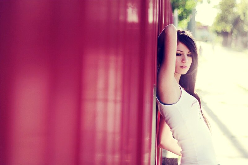 Woman Leaning on Red Wall