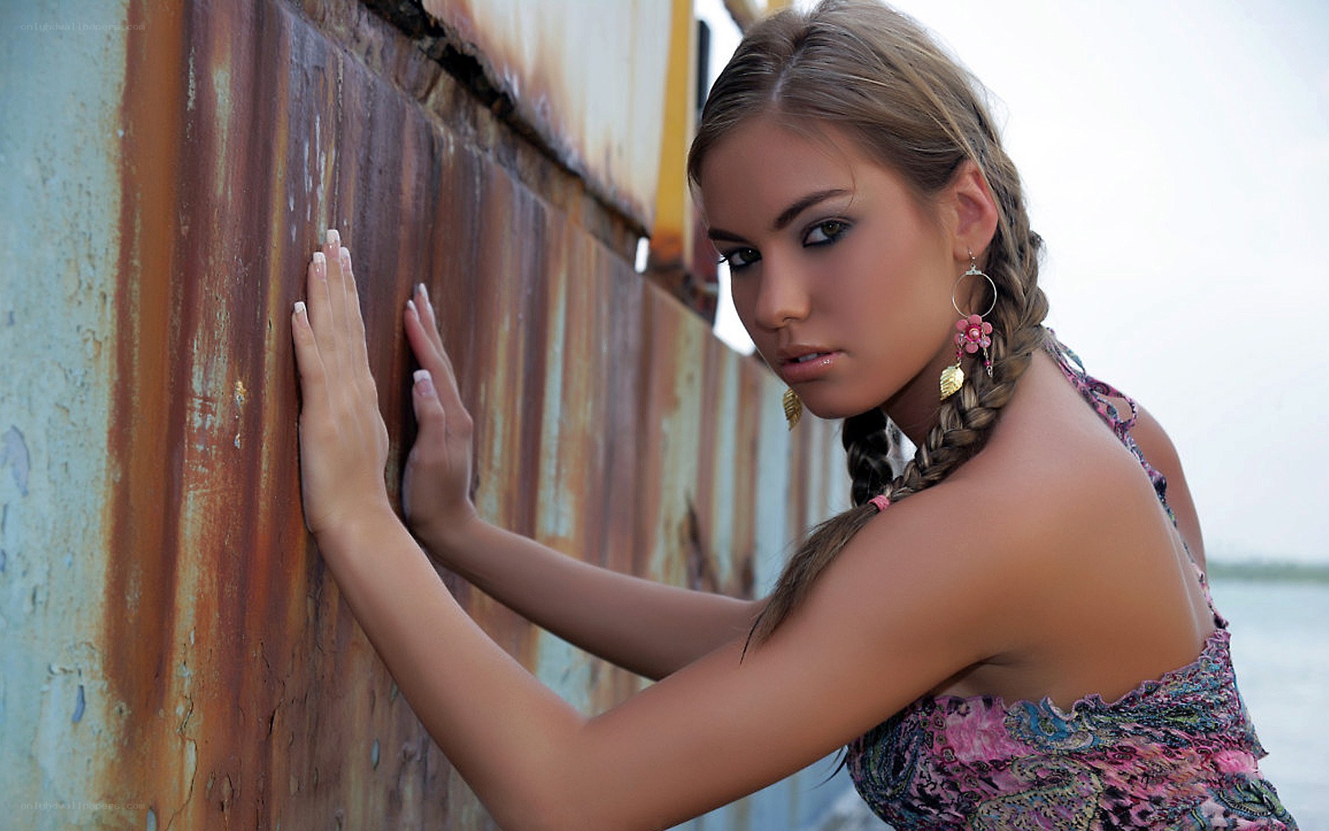 woman leaning on rusty wall