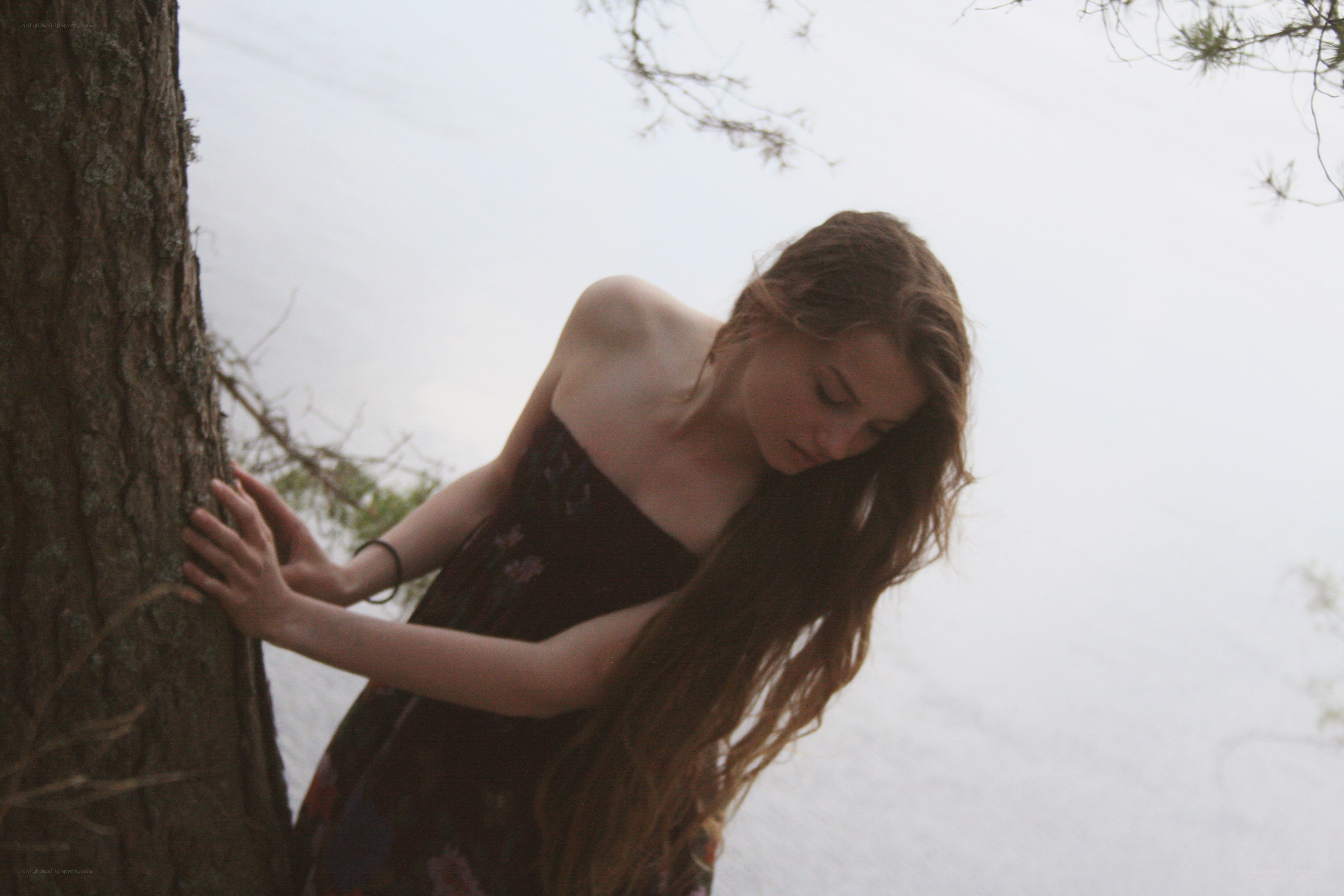 woman leaning on tree