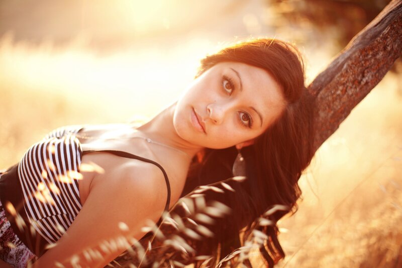 woman leaning on tree at sunset