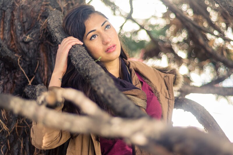 woman leaning on tree branch