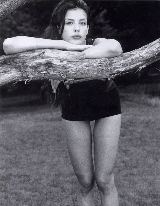 woman leaning on tree branch