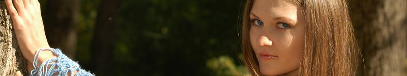 woman leaning on tree in forest