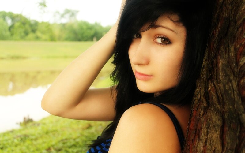 woman leaning on tree outdoors