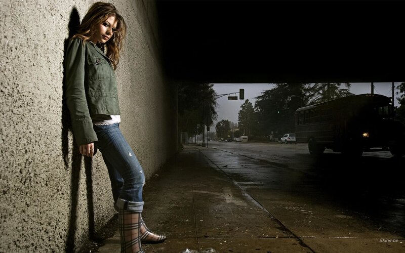 woman leaning on wall at night
