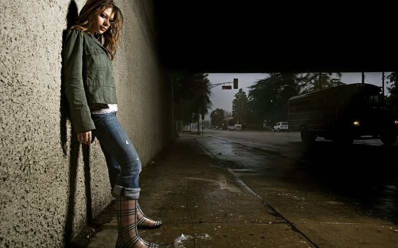 woman leaning on wall in rain