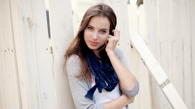 woman leaning on white fence