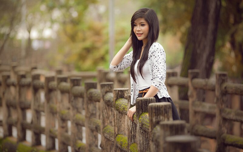 woman leaning on wooden fence