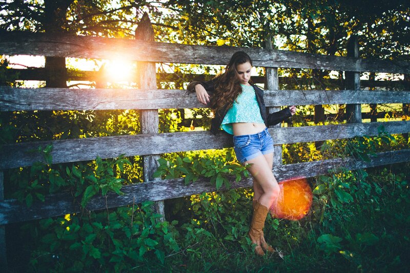 Woman leaning on wooden fence