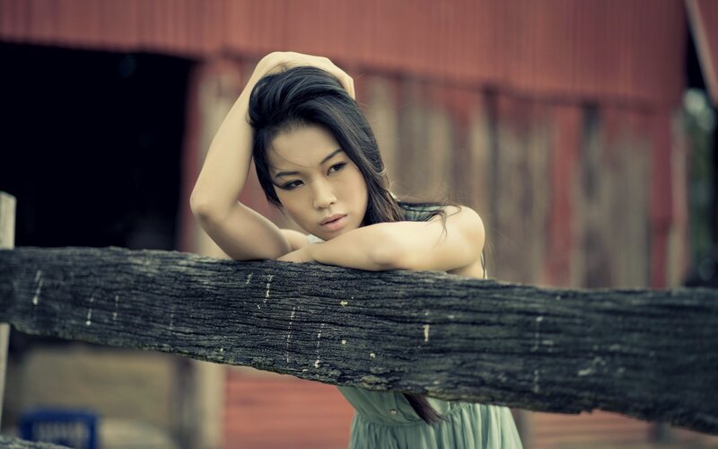 woman leaning on wooden fence