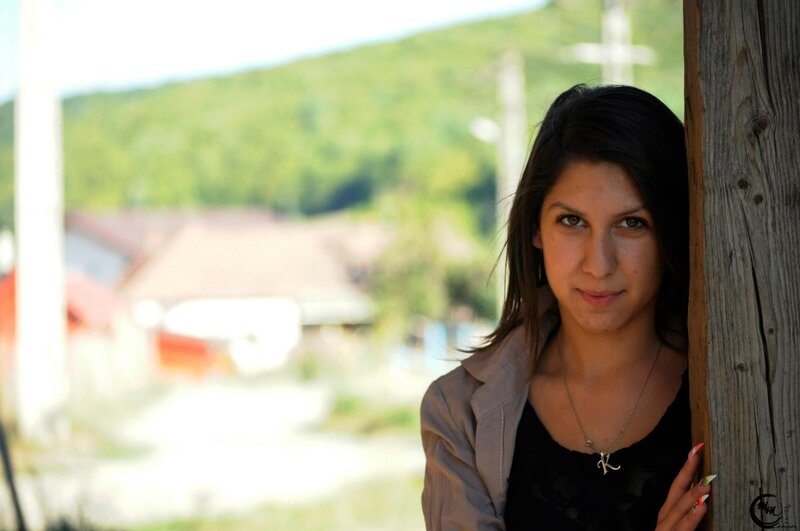 woman leaning on wooden post