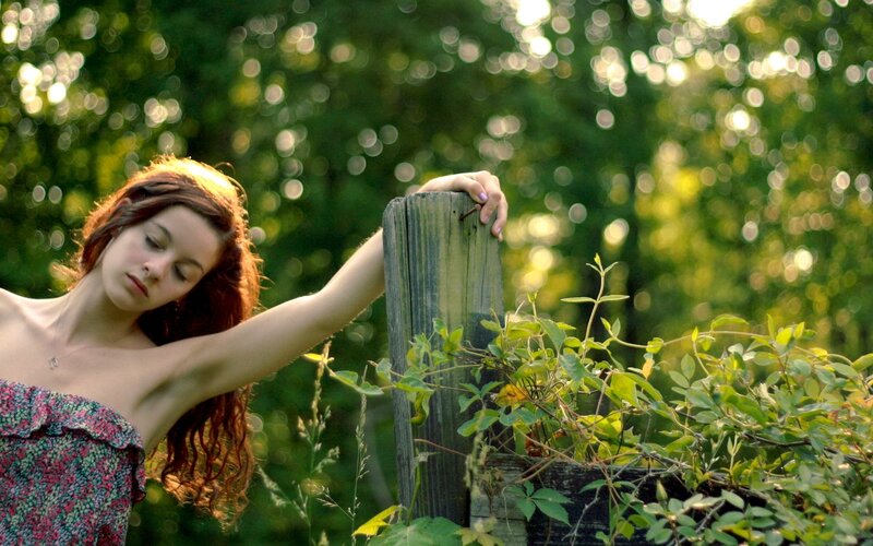 woman leaning on wooden post