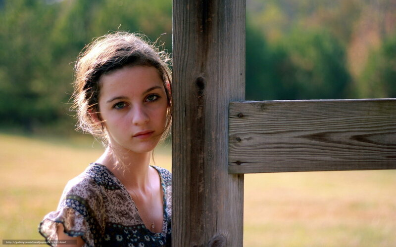 woman leaning on wooden post
