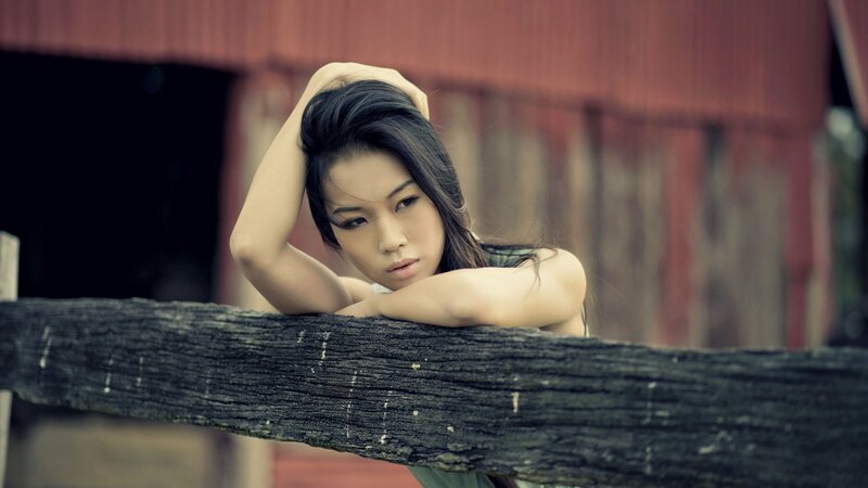 Woman Leaning on Wooden Rail — Brown