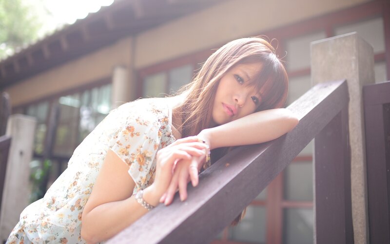 woman leaning on wooden railing
