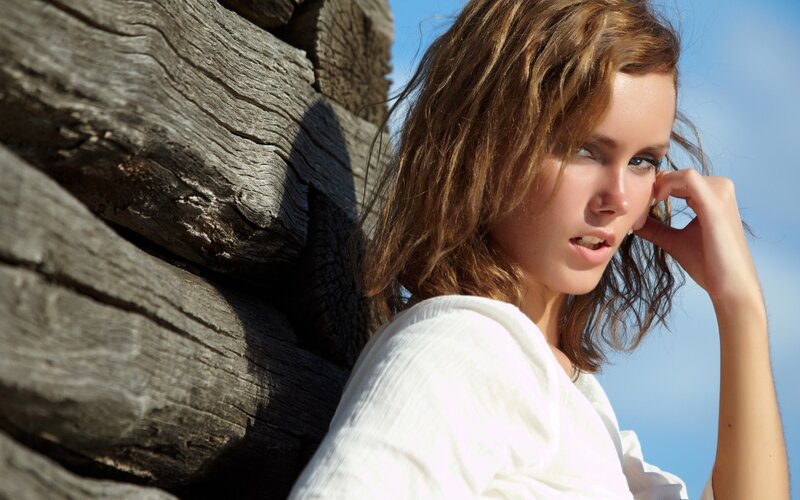 woman leaning on wooden wall