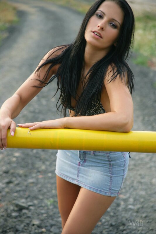 woman leaning on yellow pole