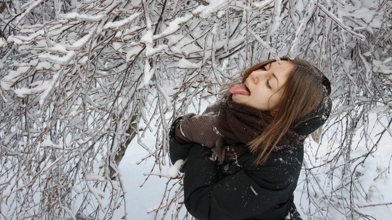 woman licking snow-covered branch