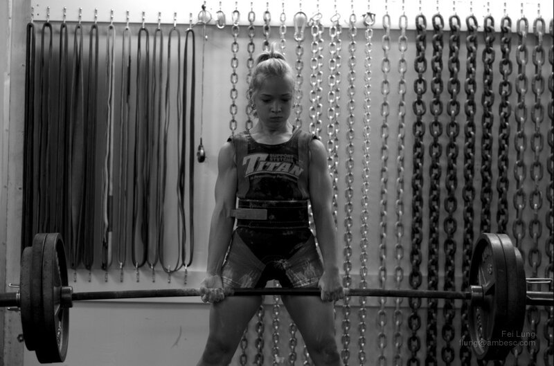 woman lifting barbell in gym