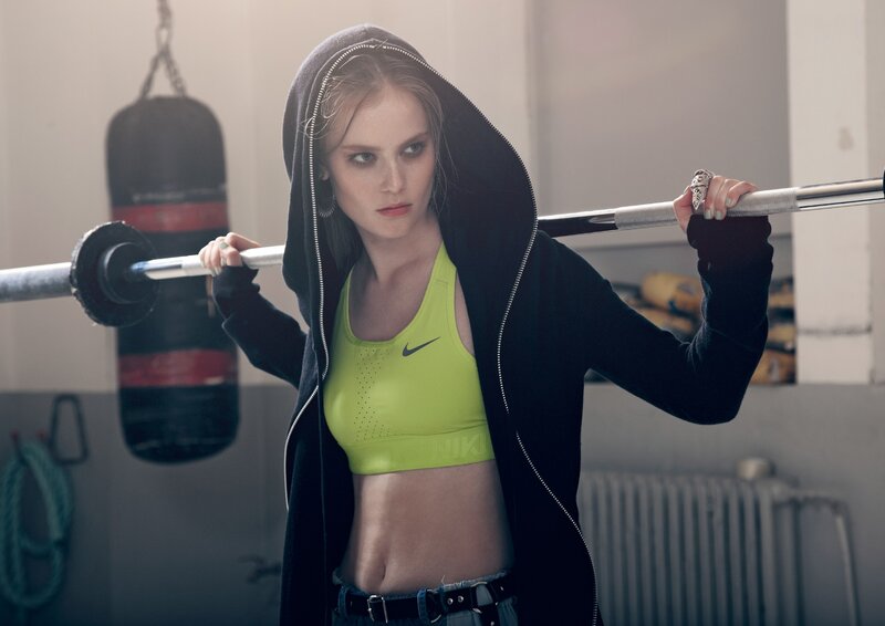woman lifting barbell in gym