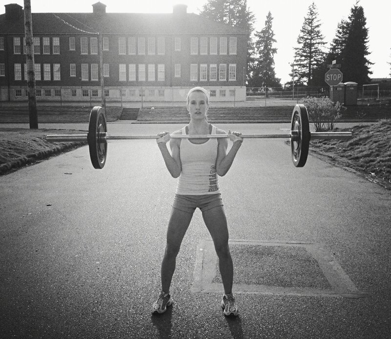 woman lifting barbell outdoors