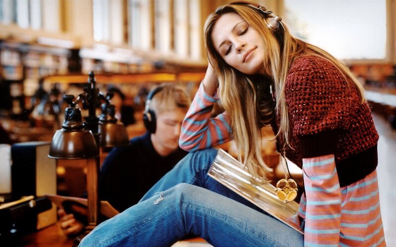 woman listening to music in library