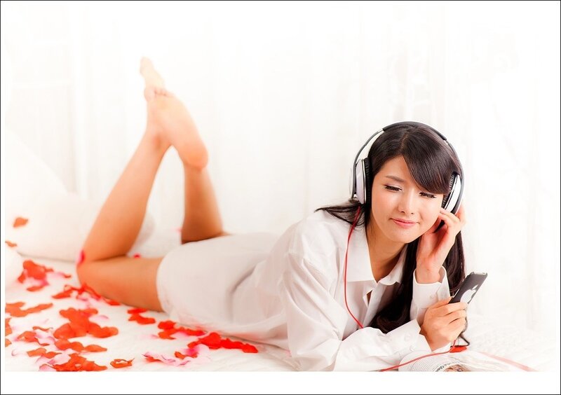 woman listening to music on bed