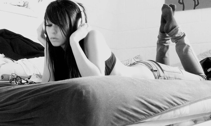 woman listening to music on bed